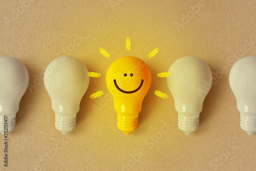 Photography Glowing yellow light bulb with smile and white light bulb turned off - Positive