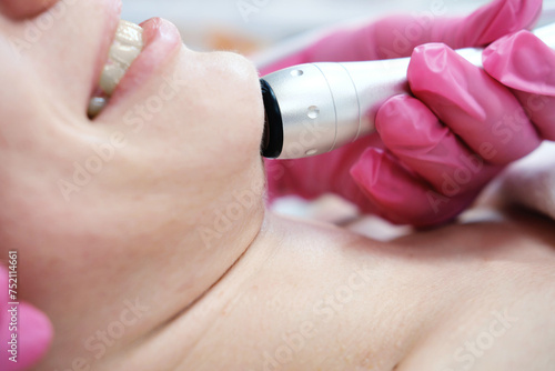 Close-up of Oxygen Mesotherapy Treatment on Face. Gloved hands perform a facial rejuvenation treatment using an oxygen mesotherapy handpiece on a patient's skin in a beauty clinic