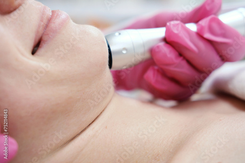 Facial Oxygen Mesotherapy Procedure. Close up. A close-up image of a client receiving oxygen mesotherapy treatment on the neck area with a practitioner wearing pink gloves