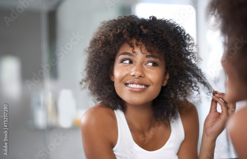 Black woman, mirror and hair with beauty and texture, curly hairstyle or frizz with morning routine in bathroom. Natural, haircare and treatment for growth, shine and cosmetics in reflection at home