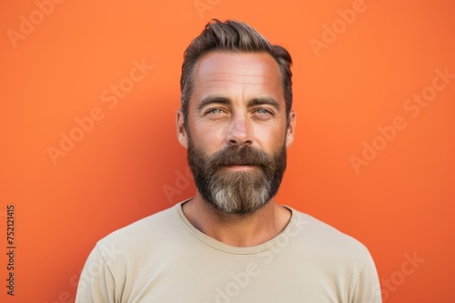 Portrait of a handsome man with a beard on a orange background