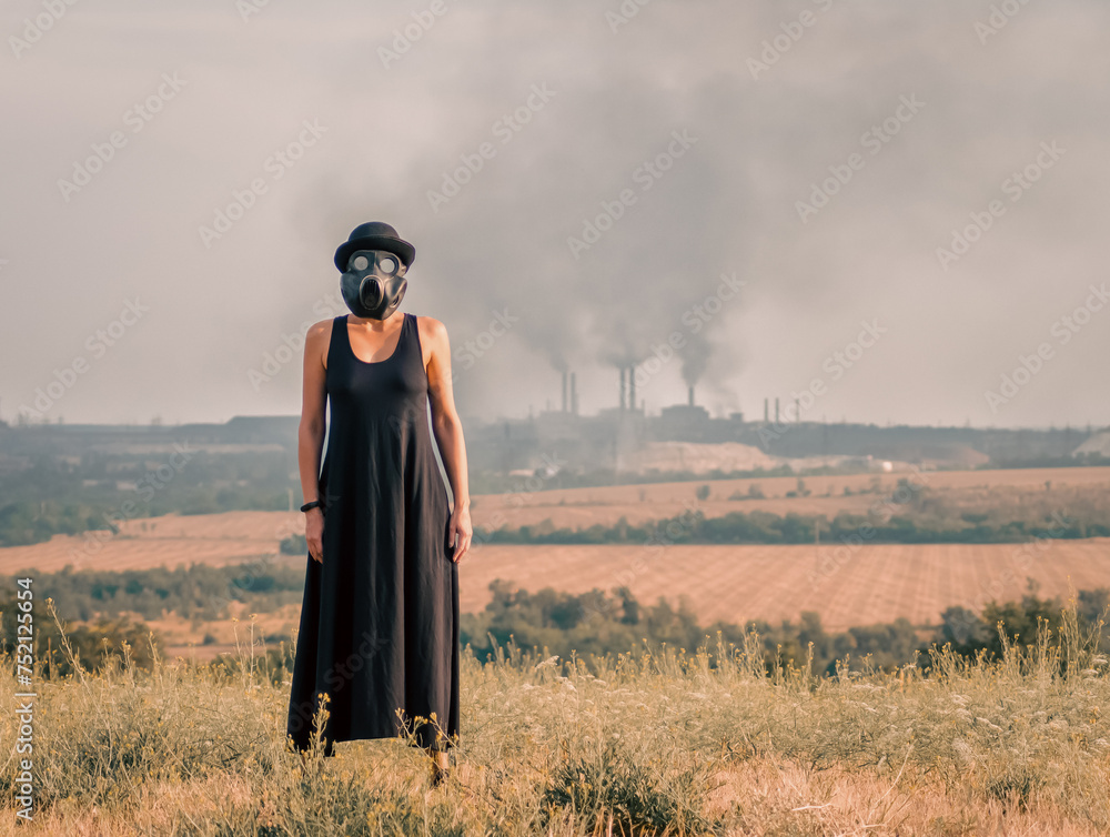 young girl in a black dress and gas mask on the background of smoking factory chimneys in Ukraine young girl in a black dress and gas mask on the background of smoking factory chimneys in Ukraine