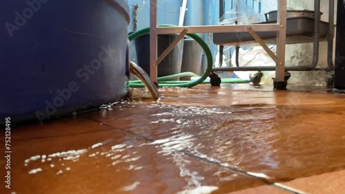 Dirty water drain from plastic tank at home on ground floor daytime. Routine maintenance. Hygiene and and clean water concept