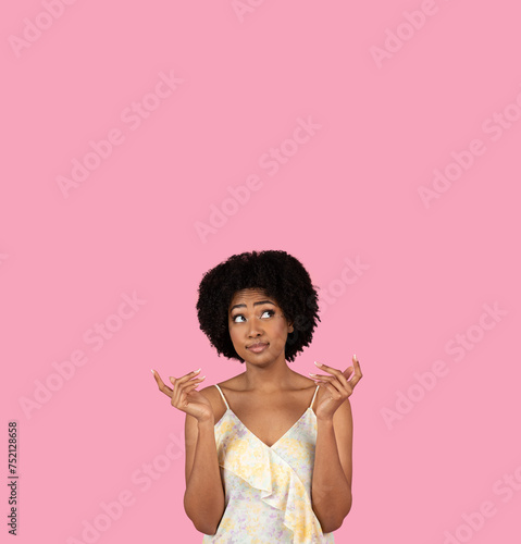 Uncertain African-American woman with fingers crossed, looking upwards and hoping for the best