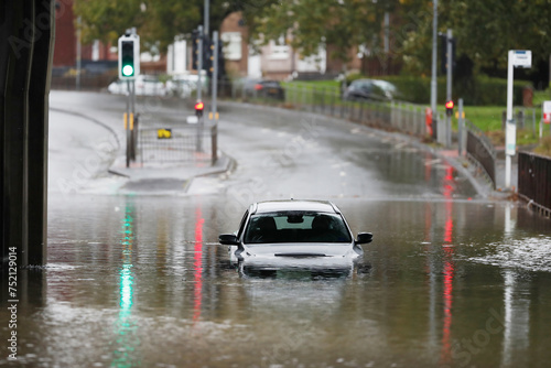 White car submerged in water after flooding in Scotland.