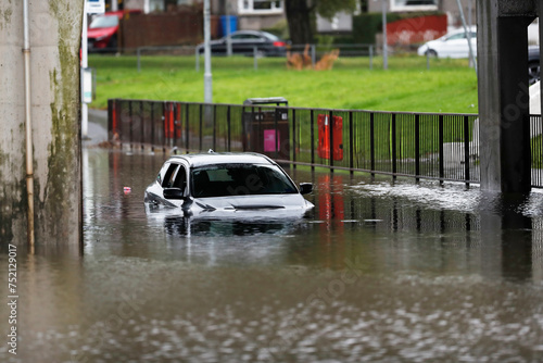 White car submerged in water after flooding in Scotland.