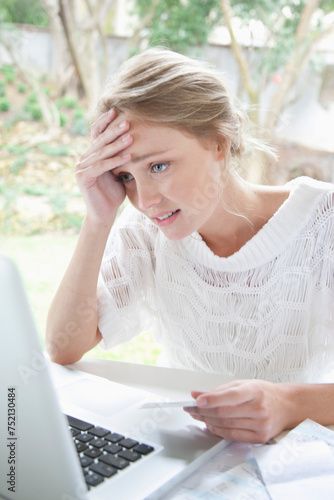 Upset Woman Holding Credit Card Looking at Laptop Screen
