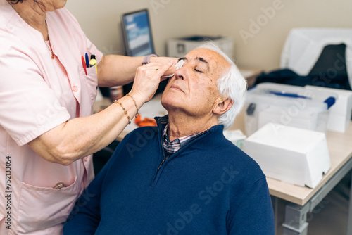 Pre-treatment care includes administering drops to a patient's eye. photo