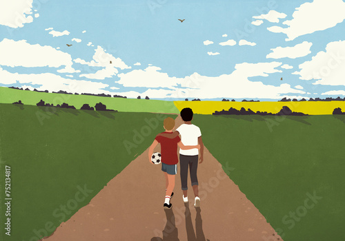 Affectionate boy friends with soccer ball hugging and walking in idyllic countryside
 photo
