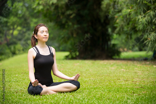 Chinese woman practicing yoga outdoors.