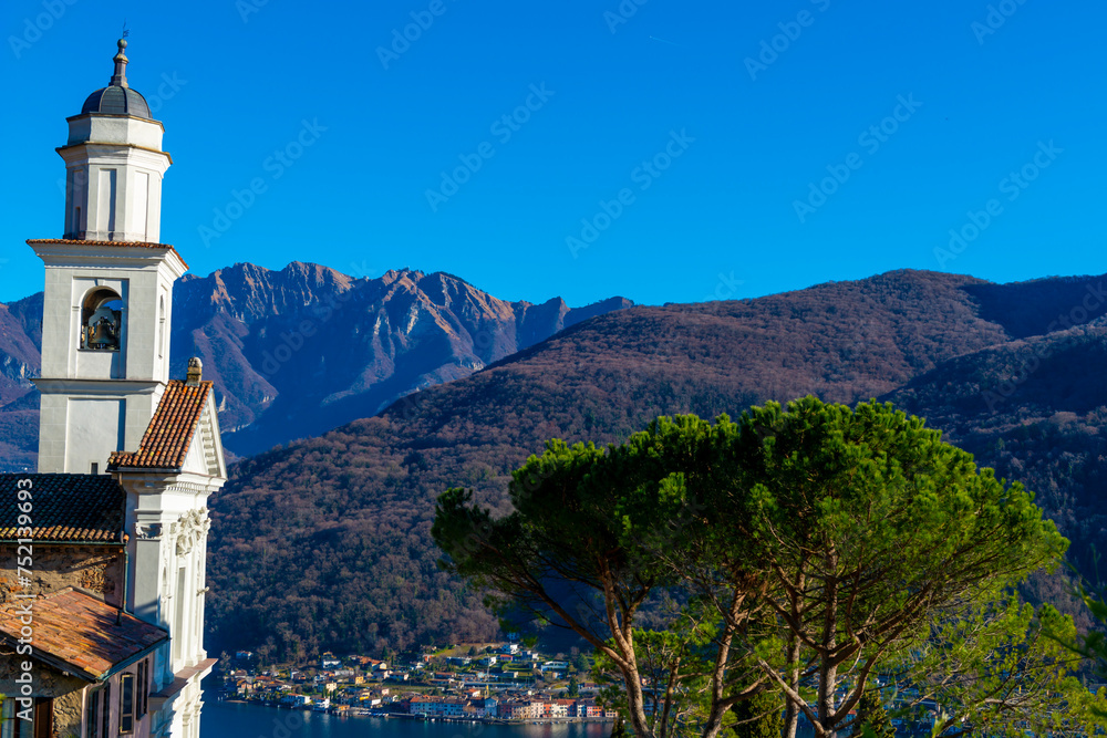 Church of Saints Fedele and Simone and Lake Lugano with Mountain in a Sunny Day in Vico Morcote, Ticino in Switzerland.