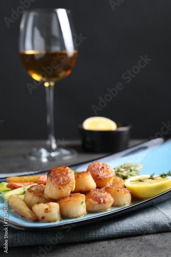 Delicious fried scallops with asparagus served on grey table