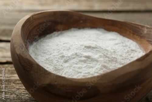 Baking powder in bowl on wooden table, closeup