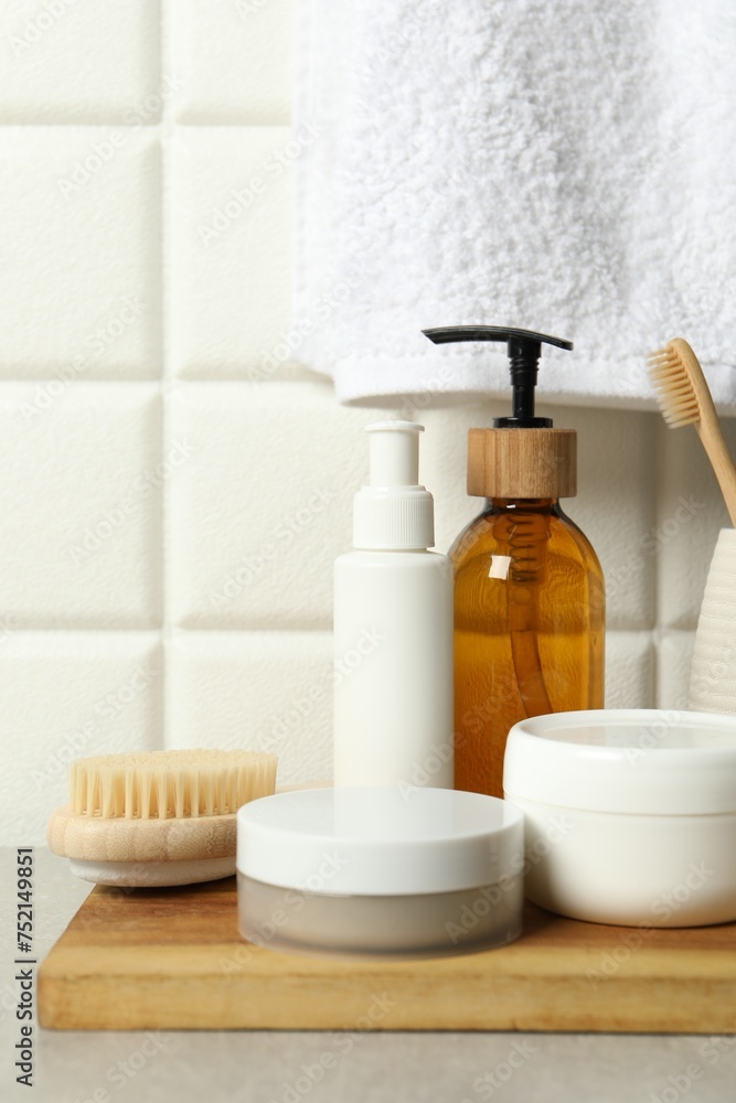 Different bath accessories and personal care products on gray table near white tiled wall Different bath accessories and personal care products on gray table near white tiled wall