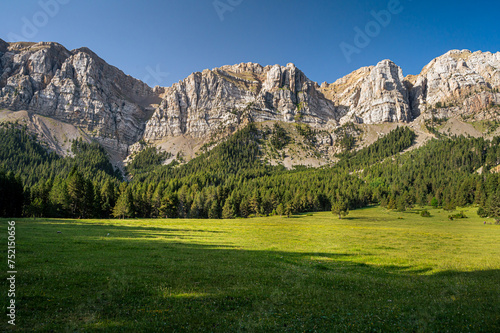 Picturesque mountain landcaspe with blue sky and green valley (high cliff mountain range)