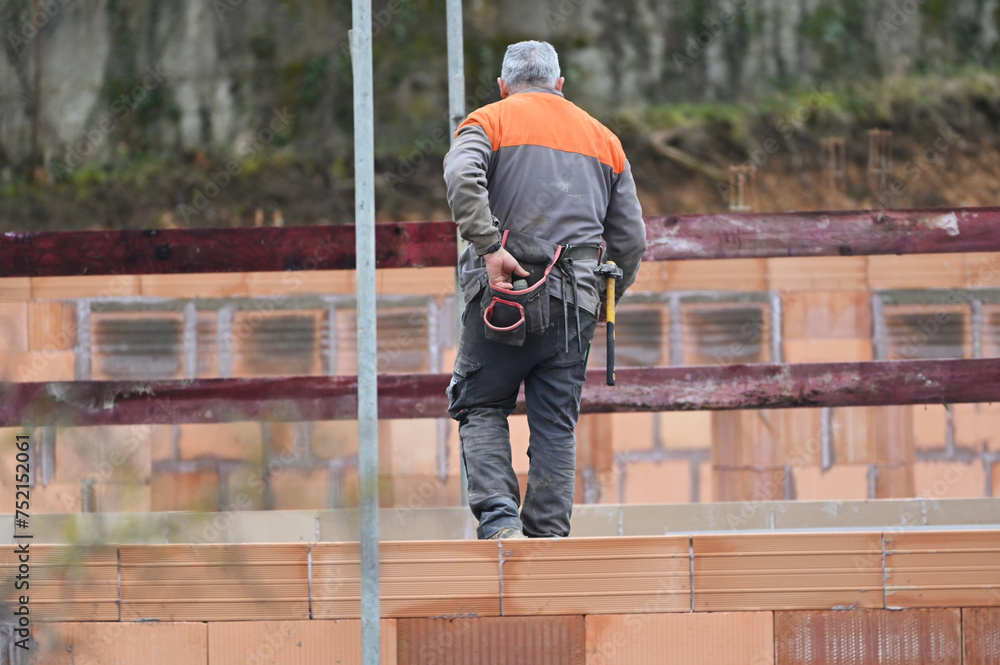 ouvrier maçon posant des briques sur un chantier de construction