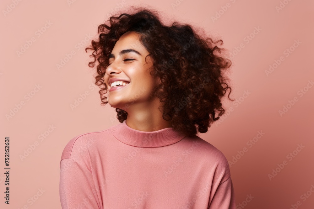 Portrait of a beautiful young african american woman with curly hair posing on a pink background Portrait of a beautiful young african american woman with curly hair posing on a pink background