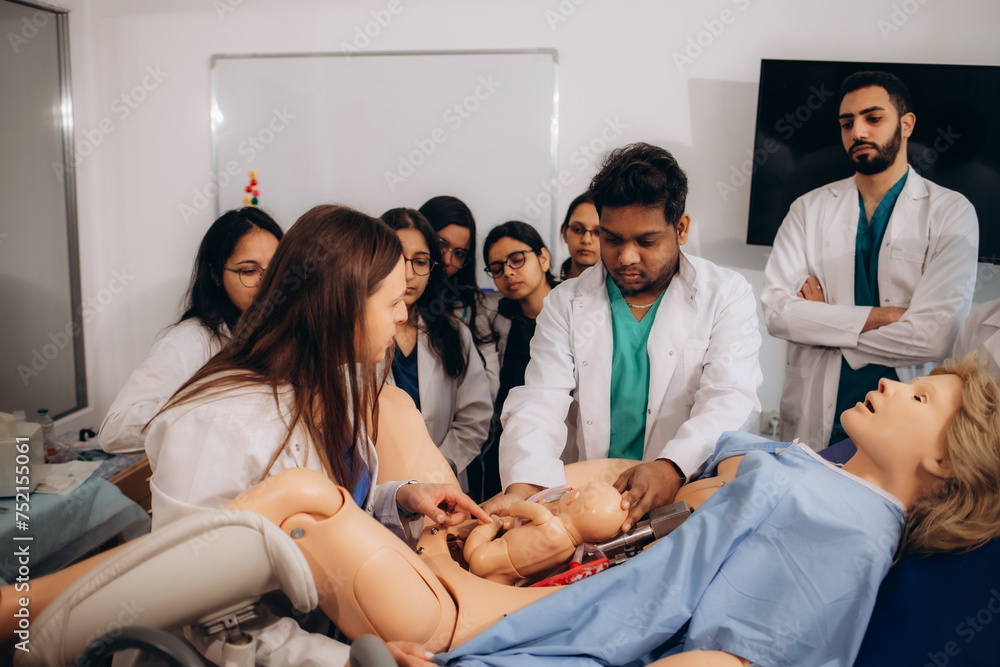 Fototapeta premium students of obstetricians and gynecologists practice childbirth on a mannequin