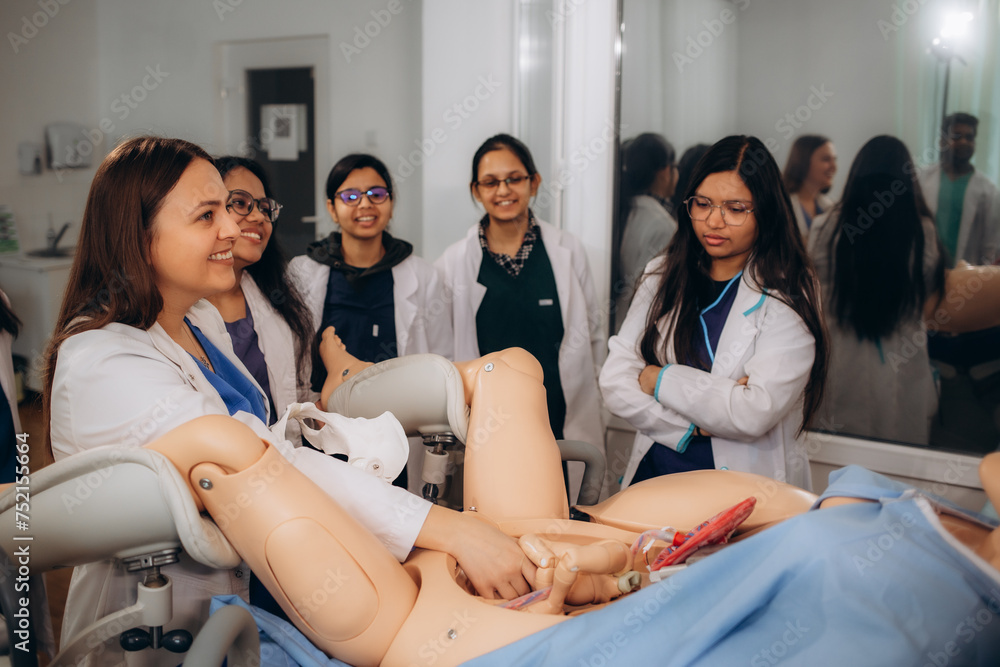 Fototapeta premium future gynecologists learn how to give birth by working with a mannequin