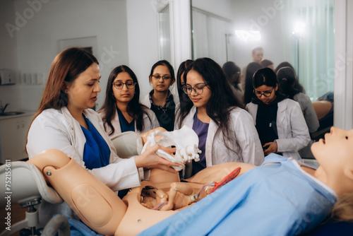 Students of obstetrics and gynecology reproduce the reality of childbirth on a special mannequin. photo