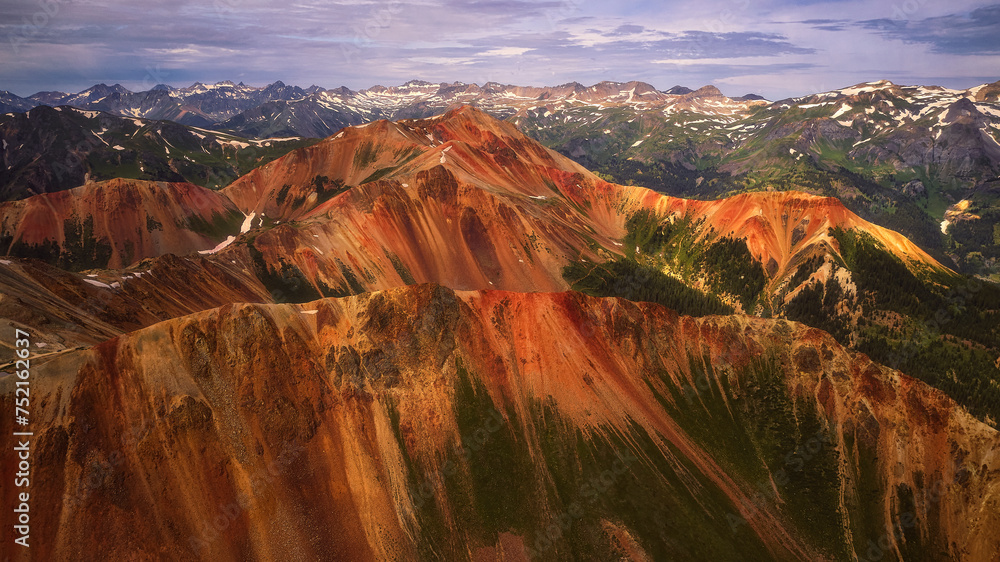 a scenic view from an air plane above mountains covered in a rainbow colored
