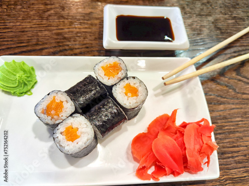 Sushi rolls with fresh ingredients served on a platter. Japanese Sushi Rolls on White Plate With Ginger Garnish. Blurred and Partial focus