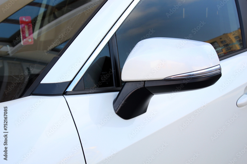 Close-up of the white side mirror of the car. Car mirror with blind spot warning. Car Mirror Cover Rearview Mirror. Close-up of the white side mirror of the car. Car mirror with blind spot warning. Car Mirror Cover Rearview Mirror.