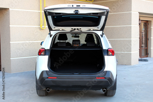 New white SUV open trunk. Modern car SUV with open empty trunk. Modern wagon car open trunk. Car boot is open.