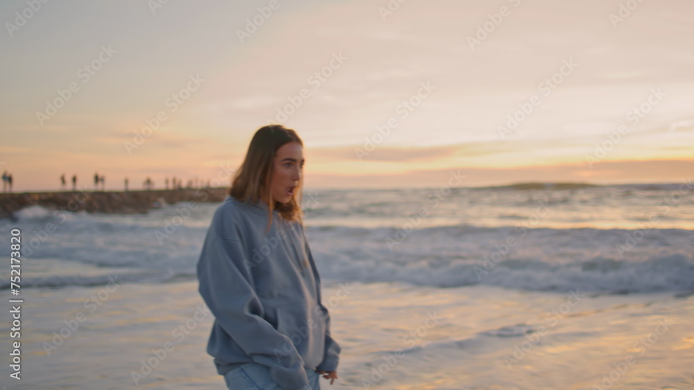 Happy girl walking sunset sea water. Carefree young woman running ocean waves Happy girl walking sunset sea water. Carefree young woman running ocean waves