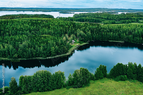 Aerial view of blue lakes and green woods  sunny summer day in Finland from above