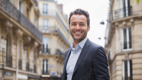 Fototapeta Naklejka Na Ścianę i Meble -  Smiling Businessman With A Backdrop Of Haussmannian Architecture And Building. Male Entrepreneur In The Streets Of Paris Capital of France 