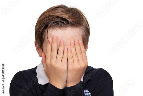 The boy covered his face with his hands on a white background.