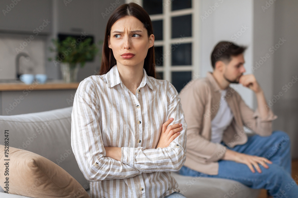Annoyed woman with arms crossed, man in background Annoyed woman with arms crossed, man in background