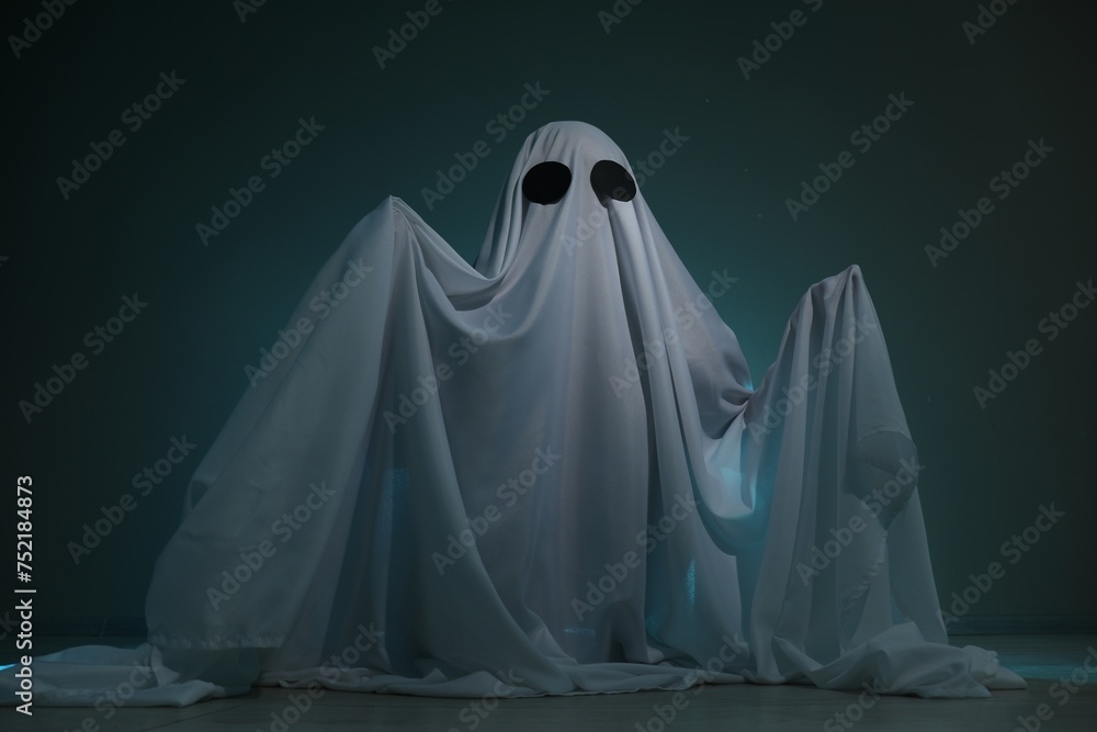 Creepy ghost. Woman covered with sheet on dark teal background