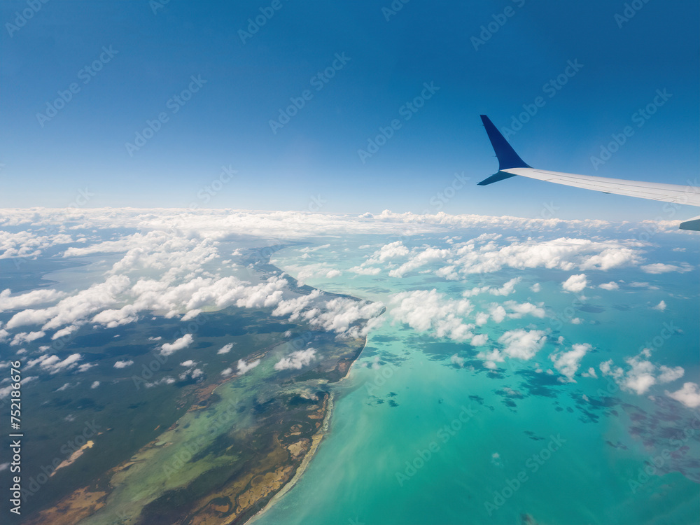 Airplane flying above ocean with clouds and sea below Airplane flying above ocean with clouds and sea below