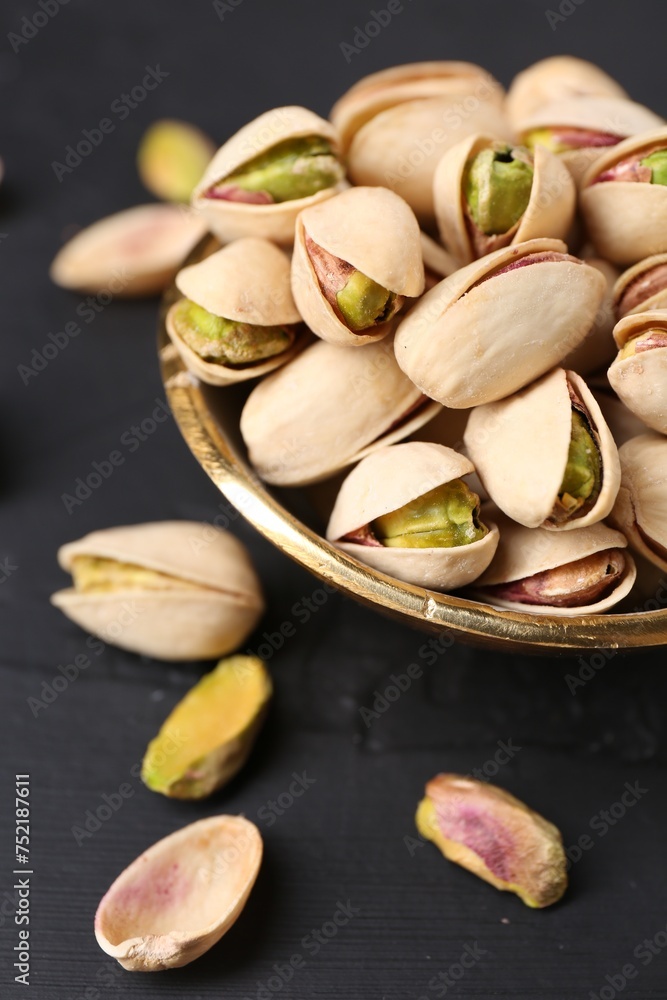 Tasty pistachios in bowl on black table, closeup Tasty pistachios in bowl on black table, closeup