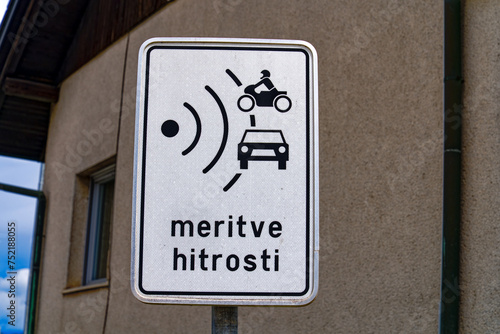 Close-up of black and white traffic sign with text speed measuring rural Slovenian village of Zabnica on a blue cloudy summer day. Photo taken August 10th, 2023, Žabnica, Slovenia. photo