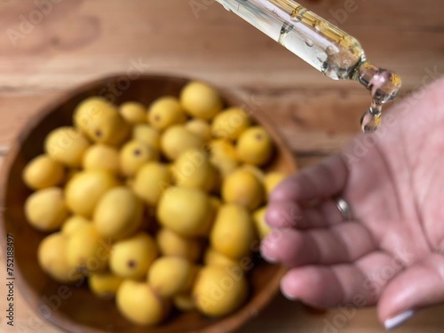 Marula fruit cosmetic oil in a dropper with marula fruit in soft focus photo