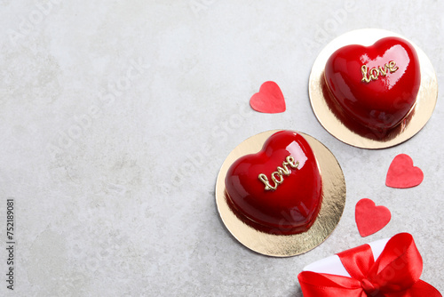 St. Valentine's Day. Delicious heart shaped cakes and gift on light table, flat lay. Space for text