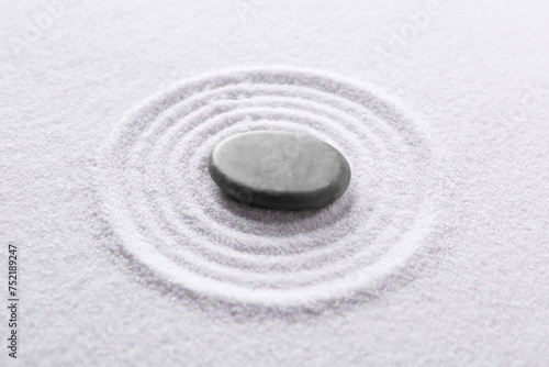 Zen garden stone on white sand with pattern