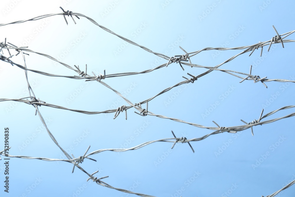 Metal barbed wire on light blue background Metal barbed wire on light blue background
