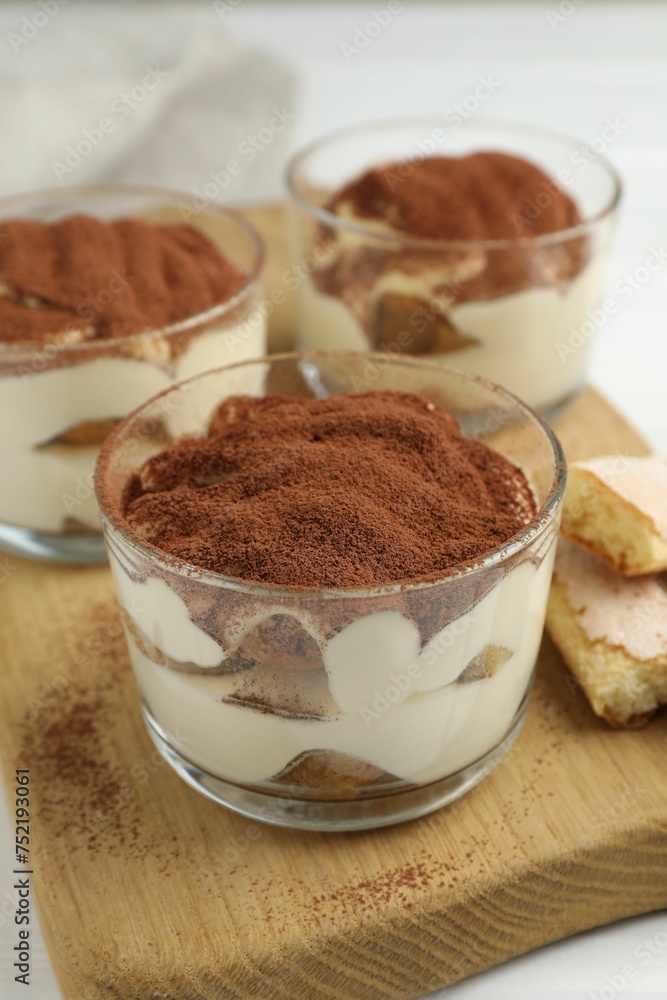 Delicious tiramisu in glasses and cookies on table Delicious tiramisu in glasses and cookies on table