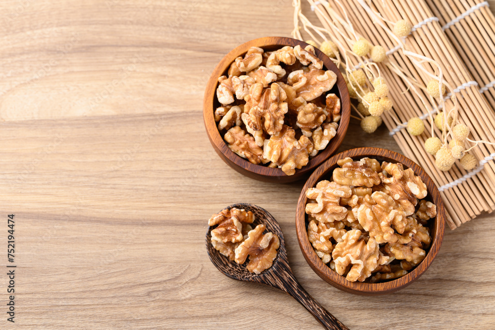 Organic raw walnuts in wooden bowl, Food ingredient, top view Organic raw walnuts in wooden bowl, Food ingredient, top view
