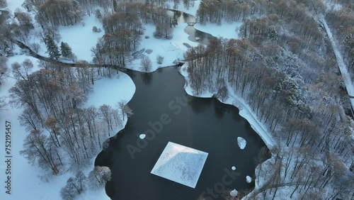 Aerial of the pyramid and lake surrounded by snow and trees in Hermann Puckler Branitzer park photo