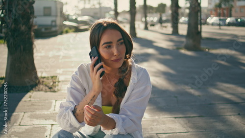 Positive girl calling phone at sunny exterior close up. Woman talking smartphone