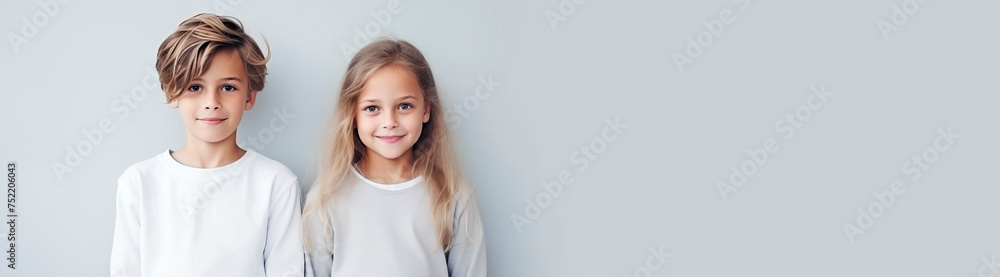 Brother and sister in light clothes, children standing next to each other and smiling, empty space for text, national siblings day, banner. Portrait of cute children on a light background Brother and sister in light clothes, children standing next to each other and smiling, empty space for text, national siblings day, banner. Portrait of cute children on a light background