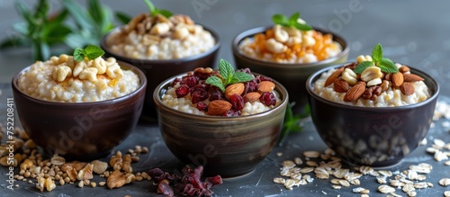 Four bowls on the table, each filled with oatmeal and topped with a variety of nuts for a wholesome breakfast.