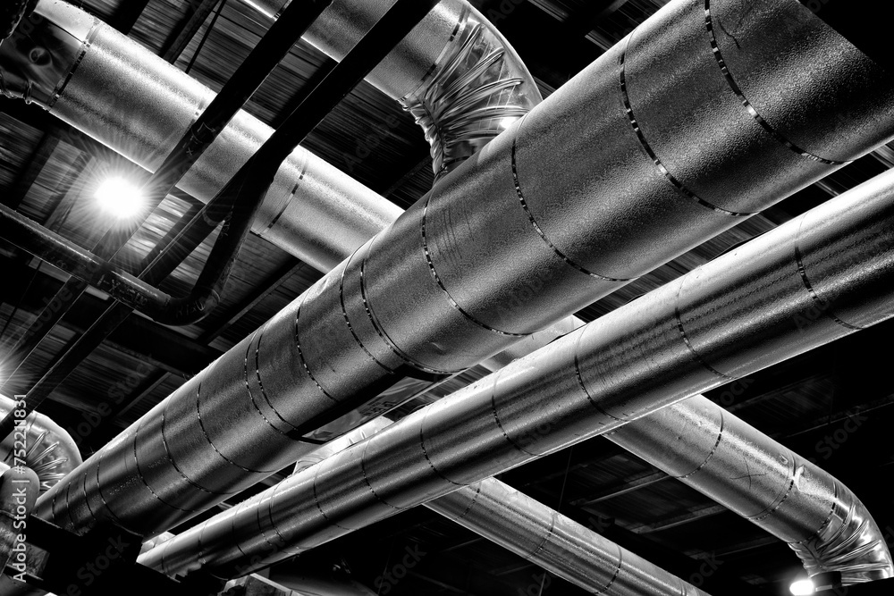 Black and white photograph of shiny pipes at an industrial oil refinery Black and white photograph of shiny pipes at an industrial oil refinery