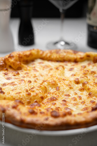 Traditional georgian cuisine. Close-up of Khachapuri with sulguni cheese on table in restaurant. Megrelian khachapuri on plate. photo