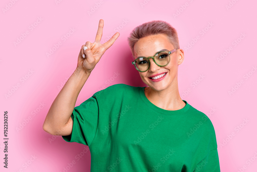Photo of pretty cheerful lady toothy smile hand fingers demonstrate v-sign isolated on pink color background Photo of pretty cheerful lady toothy smile hand fingers demonstrate v-sign isolated on pink color background